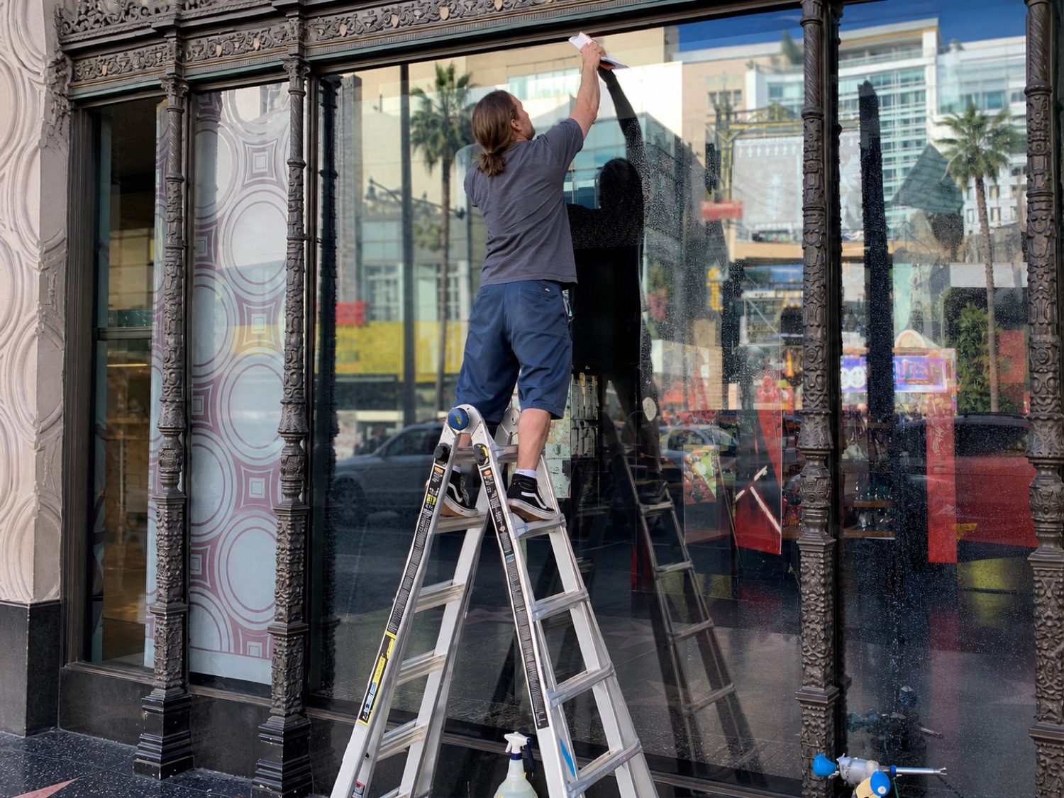 AGS installer squeegeeing clear anti-graffiti film onto a storefront window on the Hollywood Walk of Fame
