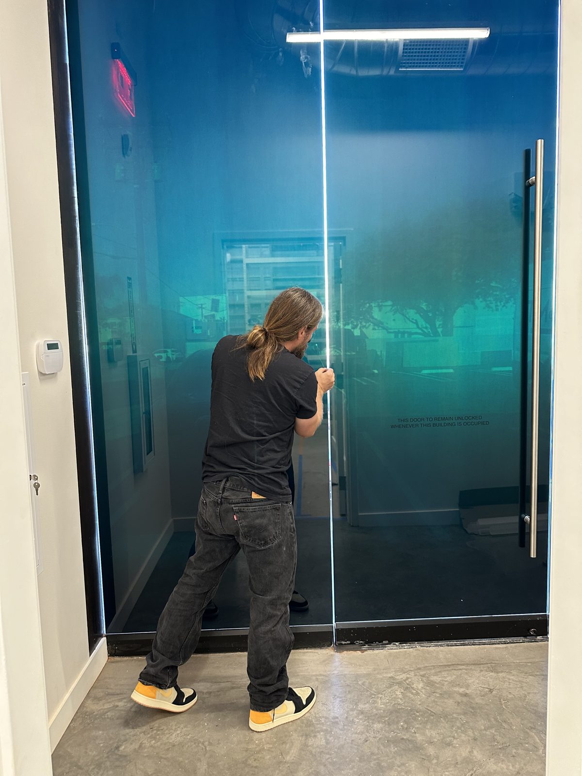 AGS installer fitting film on a glass entry door